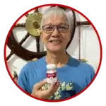 Gave - an advocate user of heartwell food supplement smiling at the camera showcasing a bottle of the product.