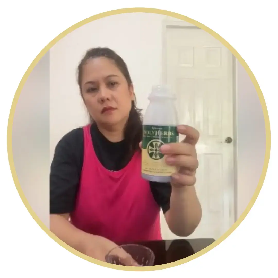 Beth - Holy herbs advocate smiling at the camera showing the holy herbs bottle