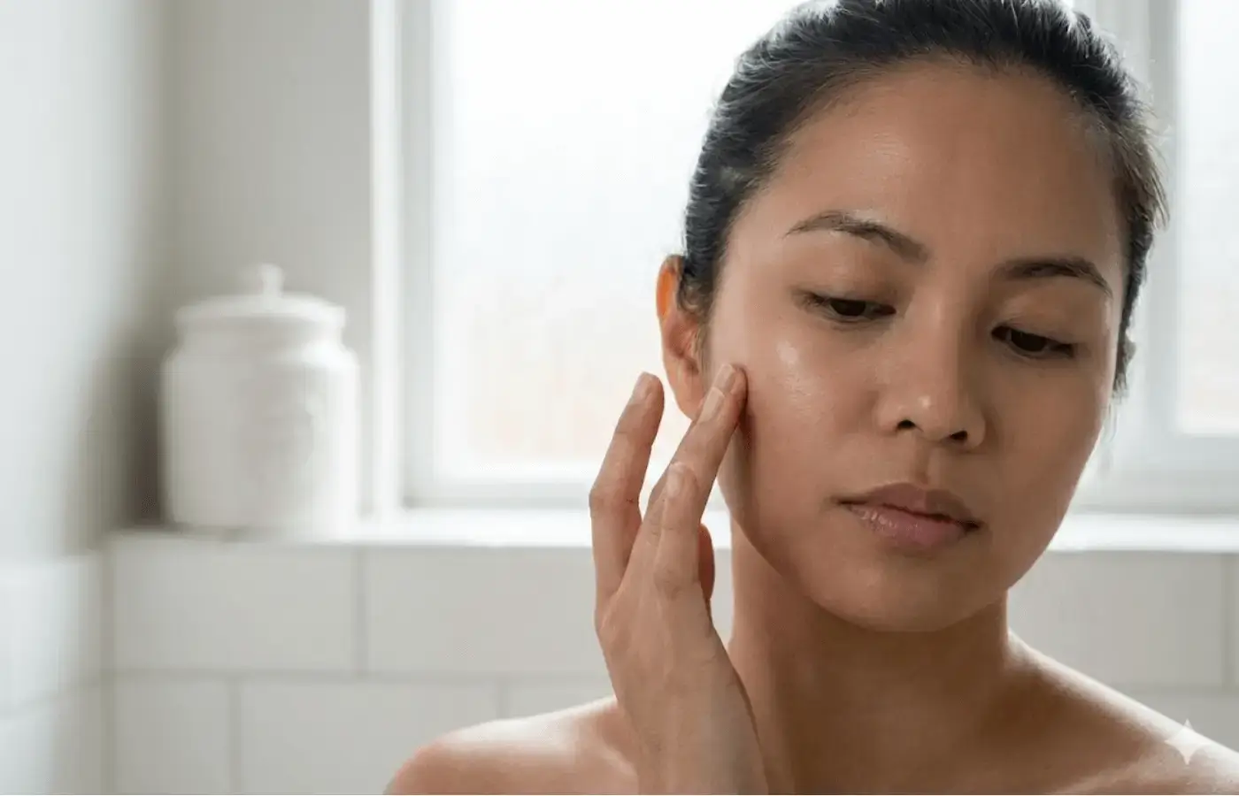 Close-up of person touching face gently during skincare routine